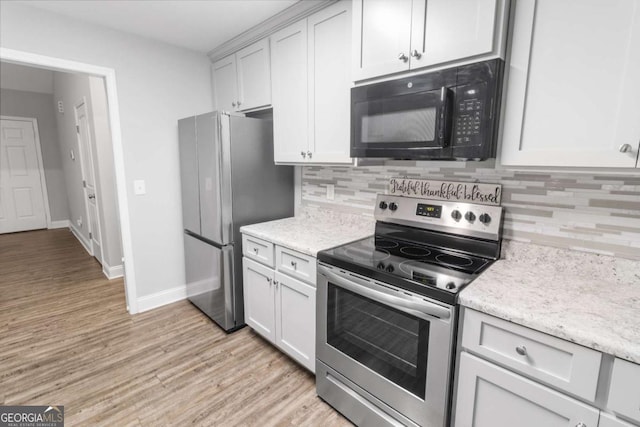 kitchen with light wood-style flooring, backsplash, appliances with stainless steel finishes, white cabinets, and baseboards