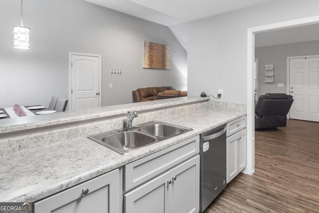 kitchen with light countertops, dishwasher, a sink, and wood finished floors