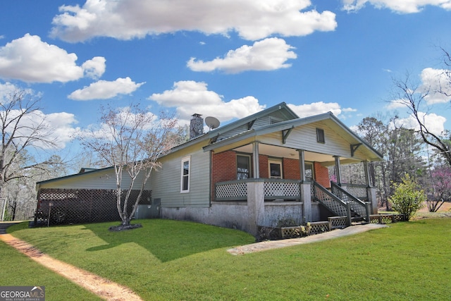 view of front of property featuring a porch, brick siding, and a front lawn