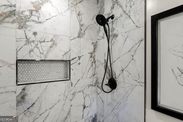 interior details featuring a marble finish shower