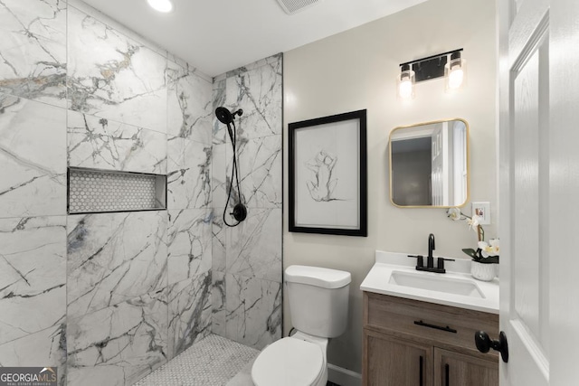 bathroom with a marble finish shower, toilet, visible vents, and vanity