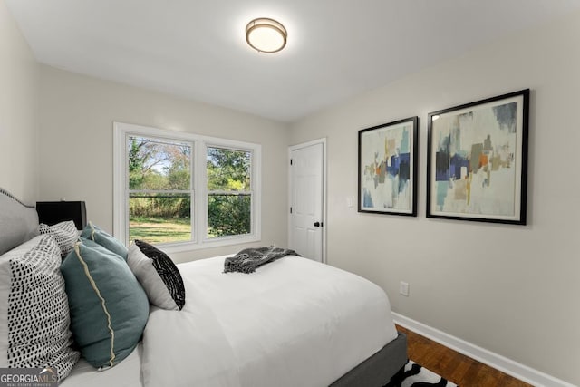 bedroom featuring dark wood-style floors and baseboards