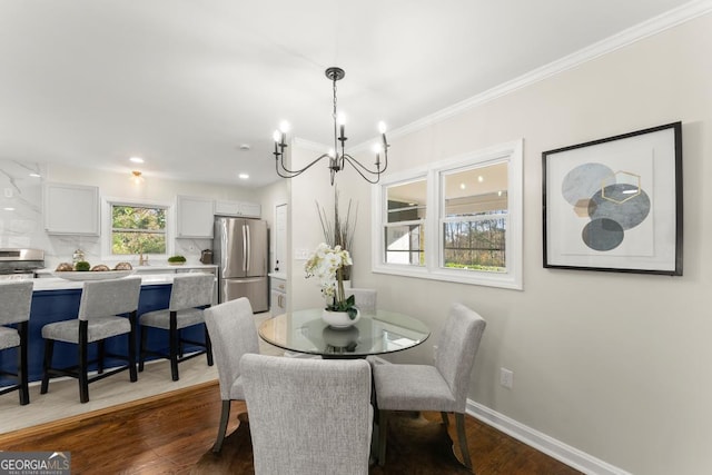 dining area with dark wood finished floors, crown molding, baseboards, and a chandelier