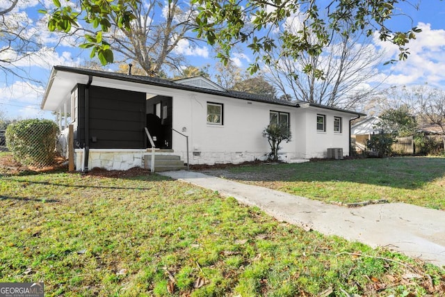 single story home featuring a front lawn and central air condition unit