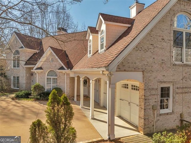 3460 Mansions Pkwy, Berkeley Lake, GA 30096 - view of front facade with a chimney and brick siding
