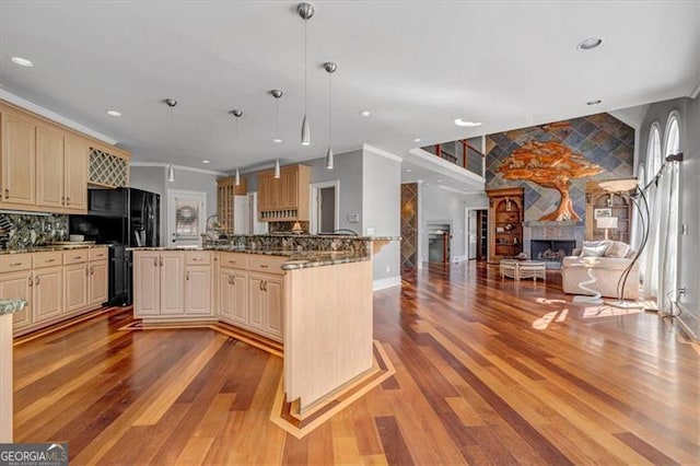 kitchen featuring cream cabinets, open floor plan, backsplash, and a large fireplace