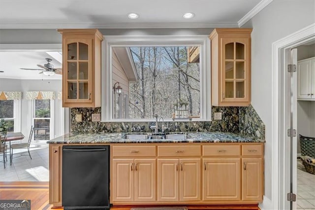 kitchen featuring a sink, dark stone counters, dishwasher, and light brown cabinetry