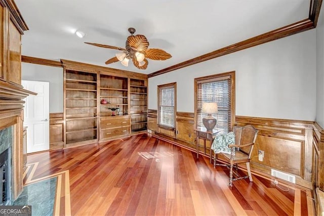 3460 Mansions Pkwy, Berkeley Lake, GA 30096 - sitting room with crown molding, a premium fireplace, wainscoting, ceiling fan, and wood finished floors