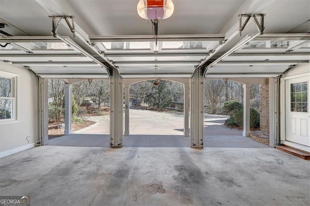 garage with baseboards and a garage door opener