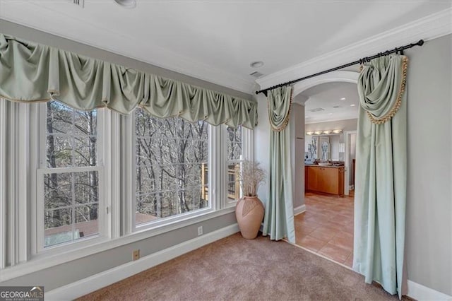 interior space with arched walkways, carpet, a healthy amount of sunlight, and ornamental molding