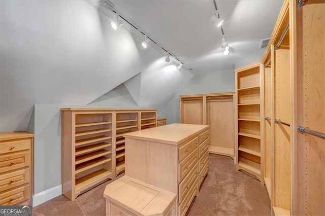 walk in closet featuring visible vents, lofted ceiling, and light colored carpet