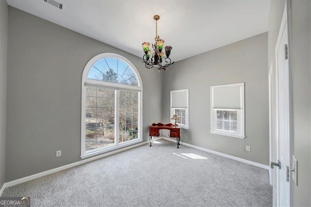 unfurnished room with a notable chandelier, carpet flooring, visible vents, and baseboards