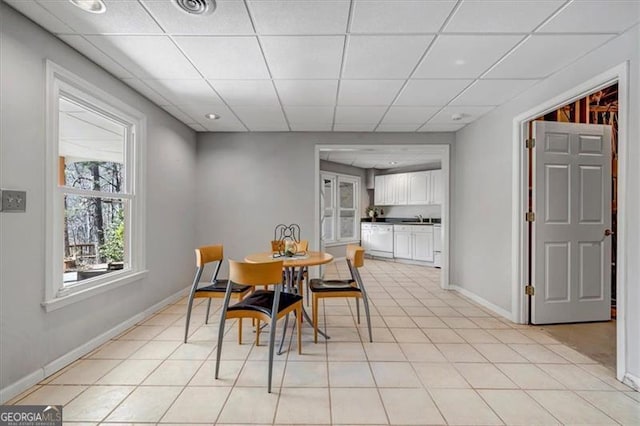 dining room with light tile patterned floors, visible vents, a paneled ceiling, and baseboards