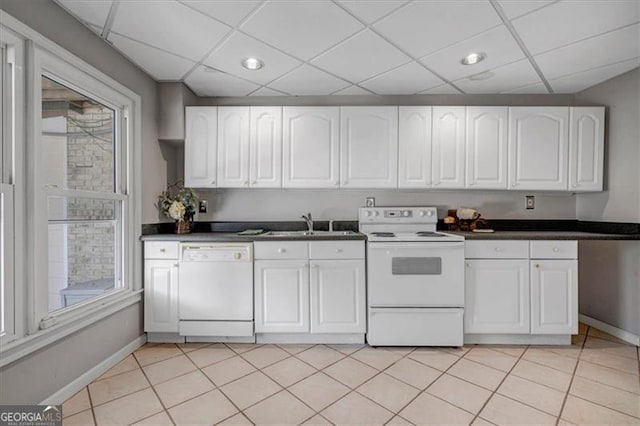 kitchen featuring baseboards, light tile patterned floors, white cabinets, white appliances, and a paneled ceiling