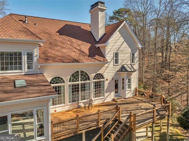 back of property featuring a deck and a chimney