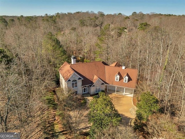 birds eye view of property featuring a wooded view