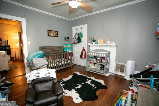 bedroom with visible vents, crown molding, and wood finished floors