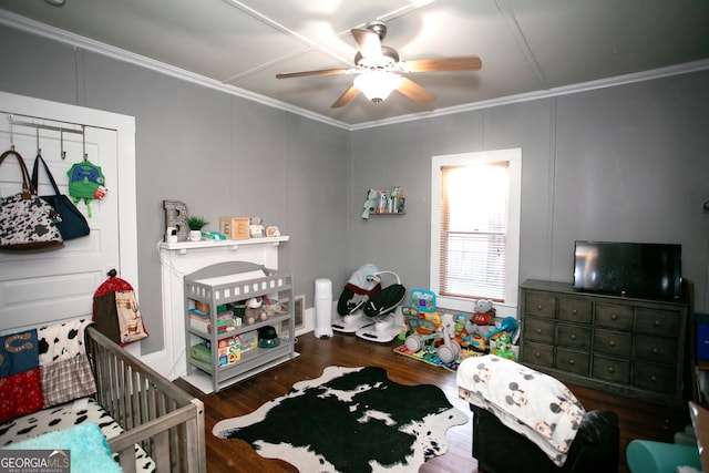 bedroom with ceiling fan, ornamental molding, wood finished floors, and a decorative wall