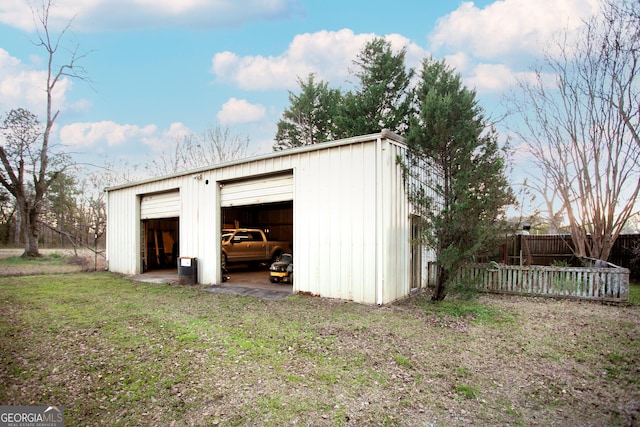 detached garage featuring fence