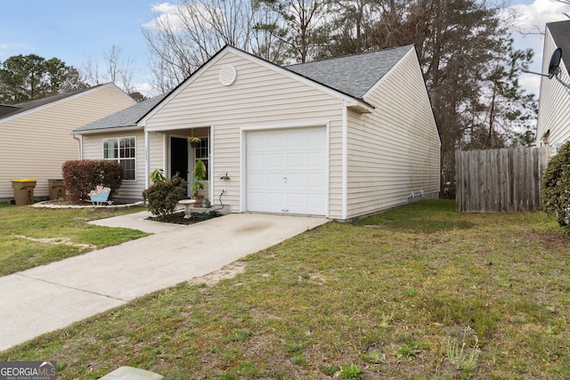 view of front of house with an attached garage, fence, driveway, roof with shingles, and a front yard