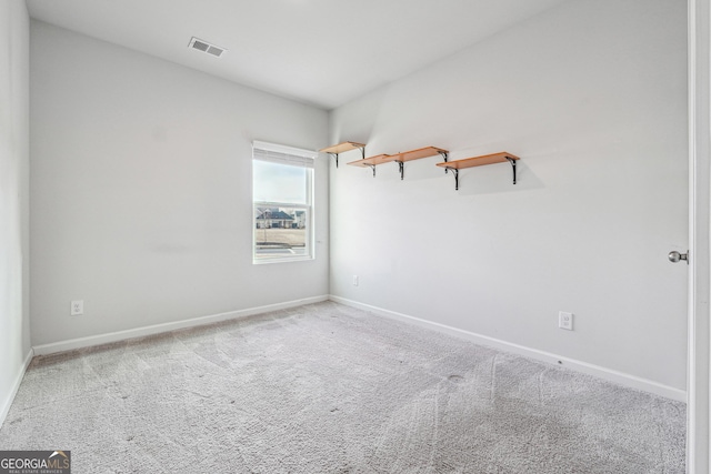 carpeted spare room featuring visible vents and baseboards