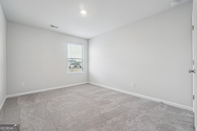 carpeted empty room with visible vents and baseboards