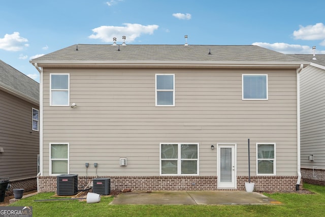 back of house featuring a yard, central AC unit, roof with shingles, and a patio area