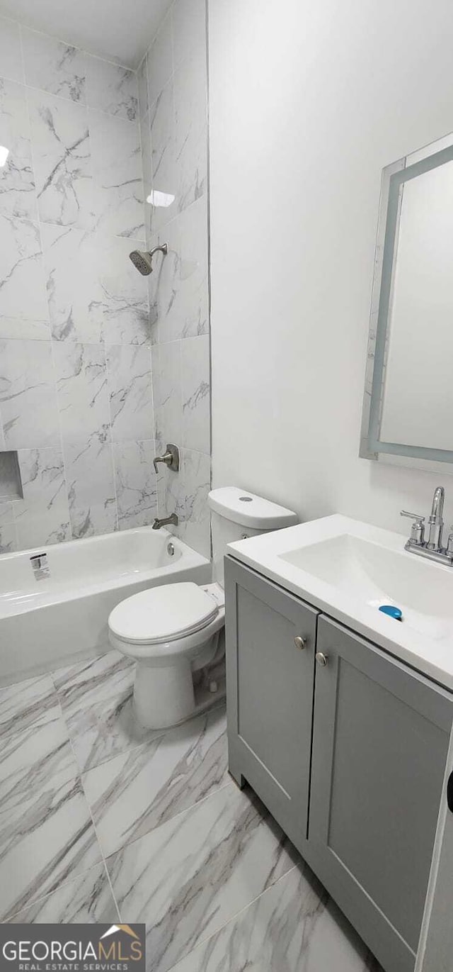 bathroom with marble finish floor, tub / shower combination, vanity, and toilet