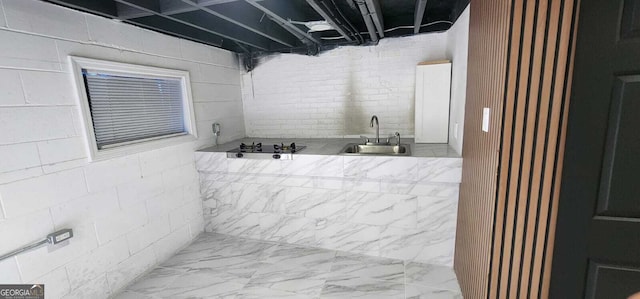 bathroom with marble finish floor and a sink