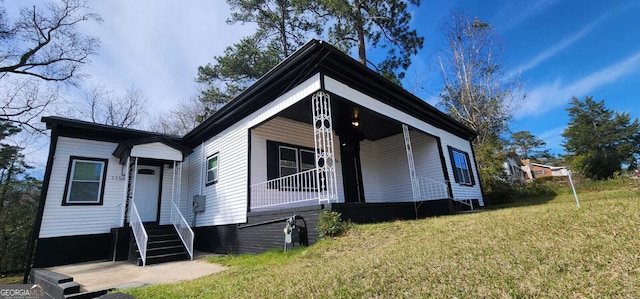 view of front facade featuring covered porch, a front yard, and entry steps