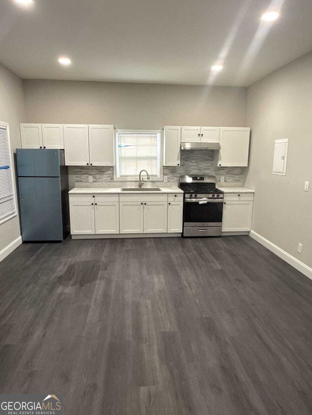 kitchen featuring decorative backsplash, gas stove, freestanding refrigerator, white cabinets, and a sink