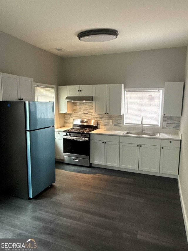 kitchen with stainless steel appliances, backsplash, a sink, and light countertops