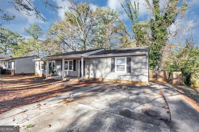 ranch-style home featuring fence