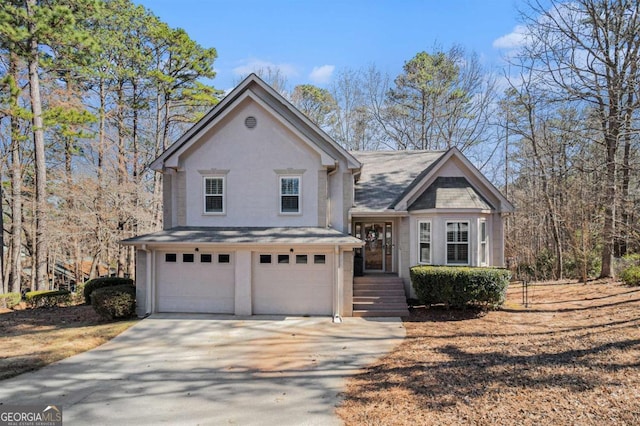 view of front of house with driveway, an attached garage, and stucco siding