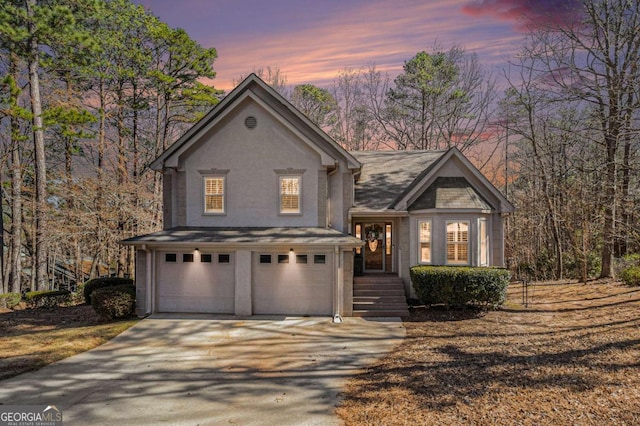 view of front of home with a garage, driveway, and stucco siding