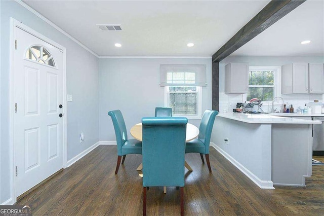 dining area with visible vents, beamed ceiling, dark wood-style floors, crown molding, and baseboards