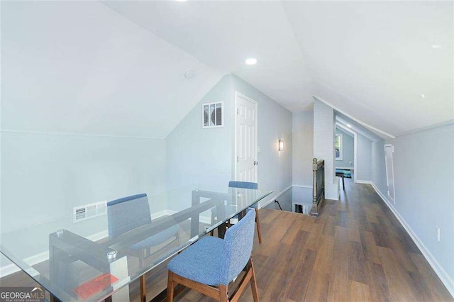 interior space with visible vents, baseboards, wood finished floors, and vaulted ceiling