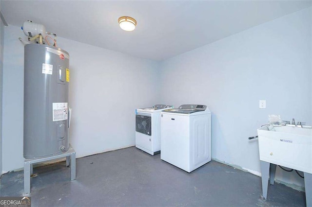 clothes washing area featuring a sink, independent washer and dryer, water heater, and laundry area