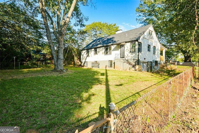 exterior space with a yard, a fenced backyard, and a chimney