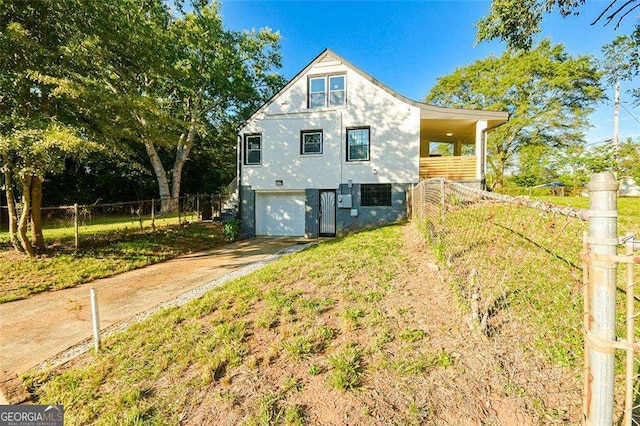 view of front of house featuring an attached garage, fence, and driveway