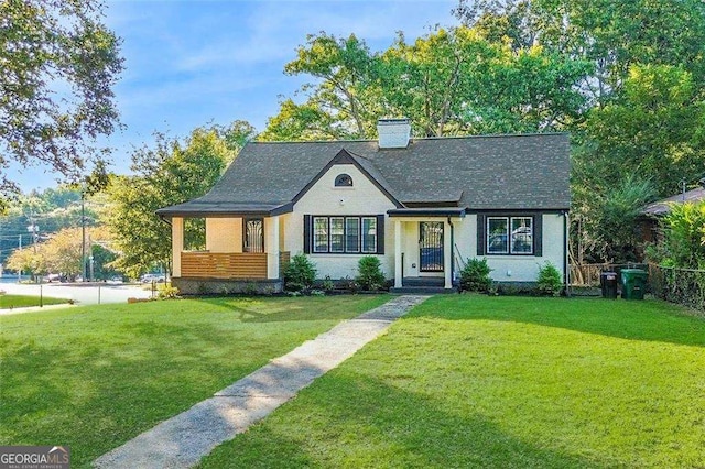 view of front of home featuring a shingled roof, a front yard, fence, and a chimney