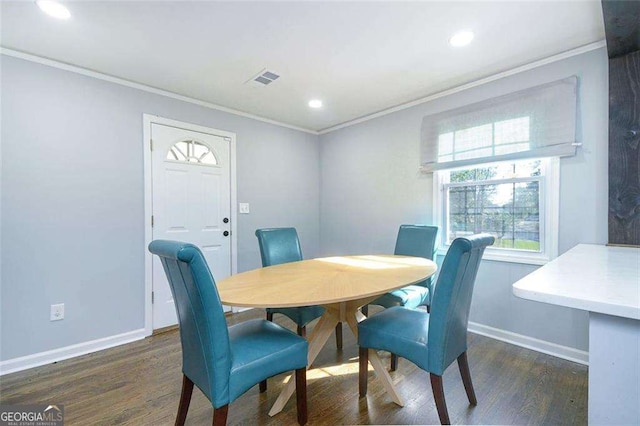 dining space featuring visible vents, wood finished floors, baseboards, and ornamental molding