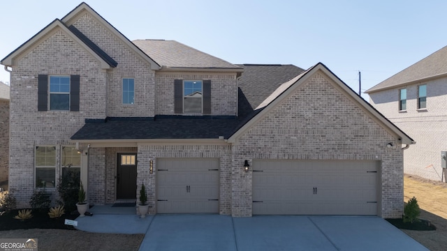 view of front of home featuring driveway, roof with shingles, a garage, and brick siding