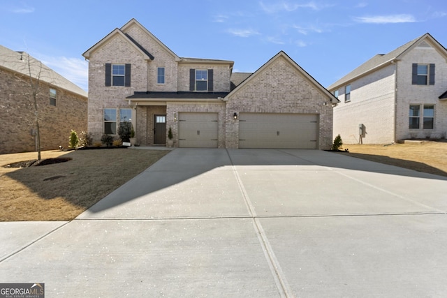 traditional-style house featuring a garage, concrete driveway, and brick siding