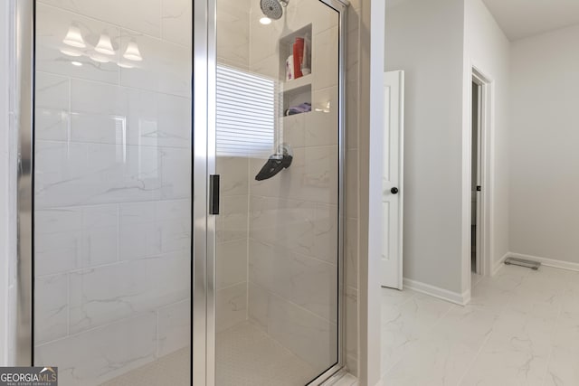 full bathroom with marble finish floor, baseboards, and a stall shower