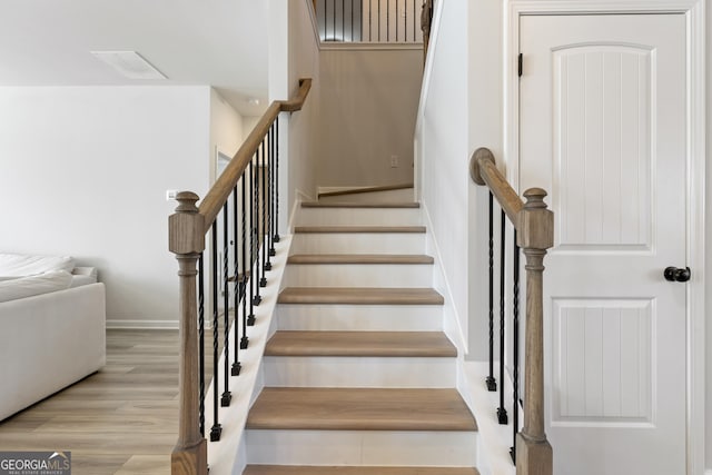 stairway featuring baseboards and wood finished floors