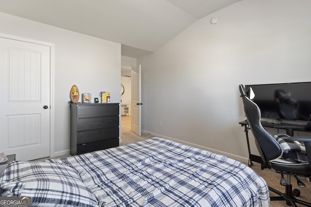 carpeted bedroom featuring lofted ceiling and baseboards