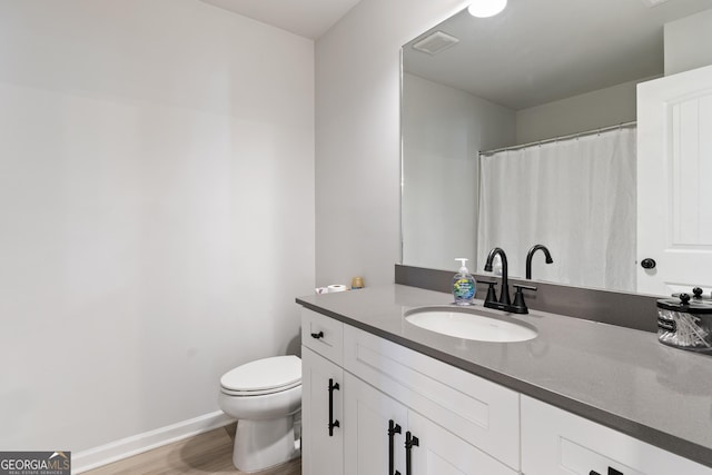 full bathroom with visible vents, toilet, vanity, wood finished floors, and baseboards