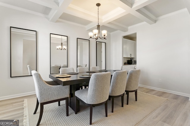 dining area featuring light wood-style floors, a notable chandelier, beamed ceiling, and baseboards