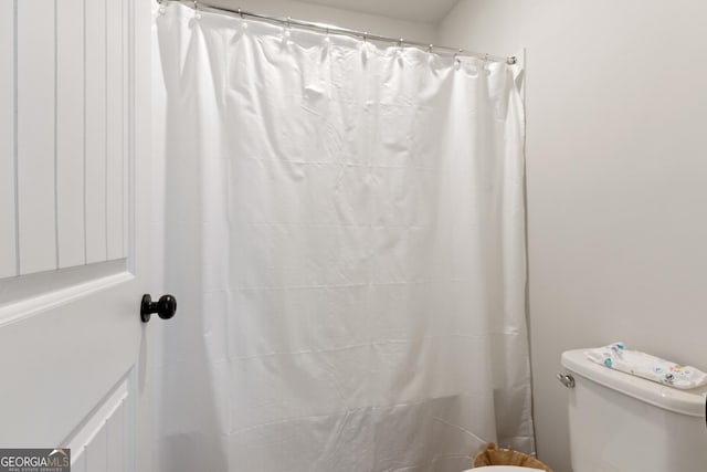 full bathroom with a shower with shower curtain and toilet